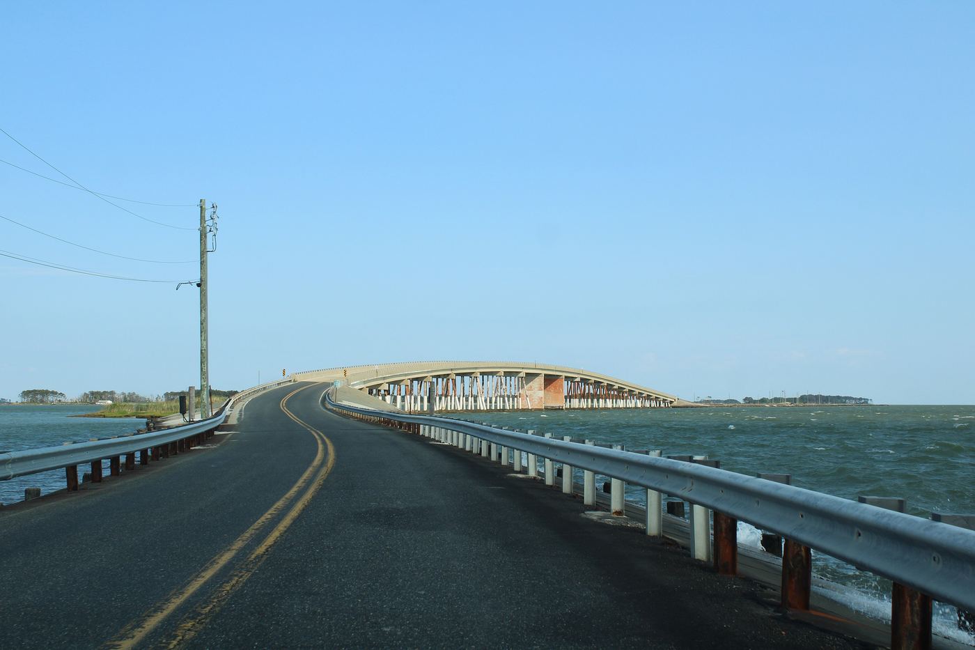 The road to Hoopers Island curving toward the arched bridge, open water on both sides