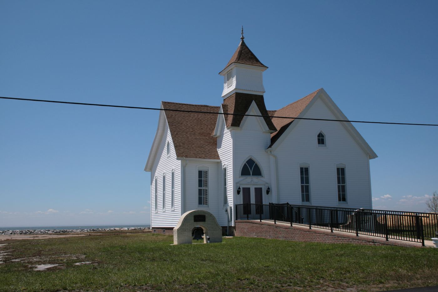 A white church in Hoopersville with the Chesapeake Bay visible behind it